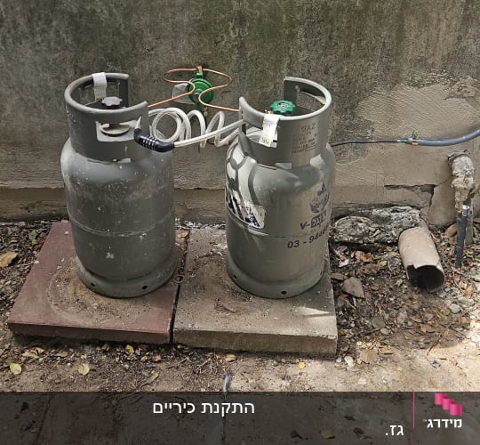 בלוני גז בחצר עם צינורות וחיבורים